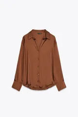 Camisa color marrón satinado, de corte holgado, con cuello solapa, escote en pico, manga larga y cierre frontal con botones.