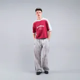 Camiseta roja con mangas blancas, corte cuadrado y logo de la marca estampado en el pecho.