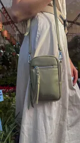 Bandolera compacta de símil cuero color rojo, con correa regulable y desmontable. Posee apertura superior, bolsillo frontal con cierre y bolsillo trasero abierto.