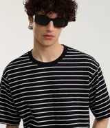 Remera boxy de algodón a rayas blancas y negras, con cuello redondo y mangas cortas.