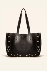 Bolso tote de cuero negro con tachas plateadas en los laterales y en la base. Tiene doble asa de hombro y un sobre interior de cuero.