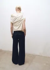 Pantalón de jean azul oscuro, corte wideleg, tiro medio, con pinzas delanteras, bolsillos laterales y traseros.