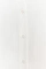 Camisa blanca de manga larga con cuello solapa y escote pico. Cierre frontal con botones.