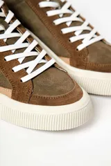 Zapatillas deportivas de cuero color crema, con detalles en gamuza color beige y verde.