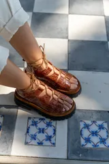 Sandalias de cuero color marrón con textura de cocodrilo, plataforma con suela track y tiras finas que se atan al tobillo.