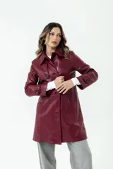 Trench de cuero color bordó, con cuello clásico, cierre frontal con botones y bolsillos laterales.