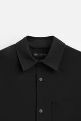 Camisa color crema de corte regular fit, confeccionada en tejido con viscosa. Tiene cuello solapa, manga larga con puños abotonados, bolsillo de parche en el pecho y cierre frontal con botones.