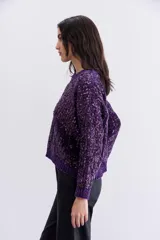 Sweater tejido en chenille suave color violeta, con calce relajado y lentejuelas aplicadas en toda la prenda. Terminaciones en punto rib.