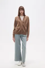 Cardigan de punto color blanco roto con motas oscuras, de manga larga y escote en V con cierre de botones frontales.