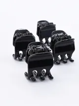 Set de cuatro pinzas pequeñas de plástico negro para el pelo.