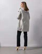 Gabardina impermeable negra, marca Weatherproof, con cierre central oculto y botones a presión. Tiene bolsillos delanteros con cierre, capucha no desmontable y forro interno de abrigo desmontable.