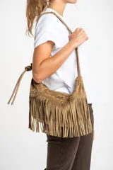 Cartera bandolera de gamuza vegana color marrón claro con flecos largos en la parte inferior.