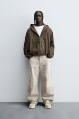 Pantalón de jean color beige, de corte amplio y tiro alto, con cinco bolsillos, efecto lavado y cierre frontal con botones.