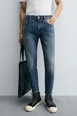 Pantalón de jean color beige, corte skinny, tiro medio, largo cropped y cinco bolsillos.