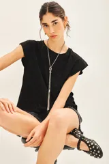 Remera negra de jersey con glitter, detalles en tela base en el frente y medallita marcaria en la espalda.
