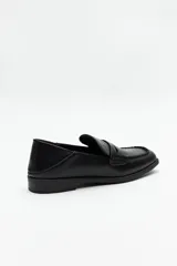 Mocasines negros de símil cuero texturizado, con punta cuadrada y detalle de bordado a tono en la capellada. Taco de 2,5cm.