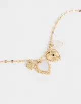 Collar largo dorado con cadena de eslabones planos y dijes colgantes: corazón con borde dorado y centro iridiscente, corazón dorado con strass y cuarzo rosa facetado.