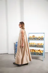 Vestido largo gris sin mangas, con escote redondo, bolsillos laterales y logo bordado en el frente.