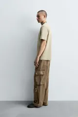 Pantalón cargo relaxed fit confeccionado en denim color marrón. Cuenta con bolsillos frontales, traseros de plastrón y multifunción en perneras. Tiene efecto lavado, bajo ajustable con trabilla y cierre frontal con cremallera y botón.