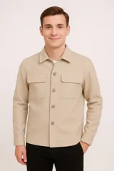 Sobrecamisa color beige con cuello clásico, cierre frontal con botones a tono, mangas largas con puños abotonados, dos bolsillos de parche en el pecho y corte recto.