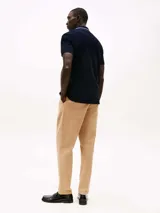 Chomba azul marino de algodón orgánico con logo de Tommy Hilfiger bordado en el pecho. Tiene cuello clásico con detalles en blanco y corte regular.