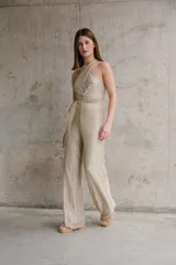 Mono largo color dorado con brillos, escote halter cruzado y lazo en la cintura.