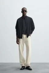 Cárdigan negro de punto con cuello perkins, cierre frontal con cremallera, manga larga y corte regular fit.