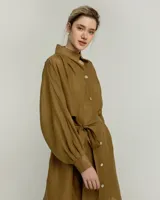 Vestido camisero negro de ramio con cuello mao, mangas largas abullonadas, cierre frontal con botones blancos y lazo a la cintura.