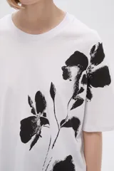 Remera blanca de corte holgado con estampado de flores negras.
