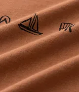 Remera masculina de algodón color tostado, con cuello redondo y manga corta. Presenta un estampado localizado de íconos playeros en negro en el pecho.