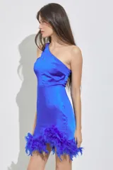Vestido corto de fiesta azul eléctrico, con diseño asimétrico de un solo hombro y falda ajustada con ruedo de plumas al tono.