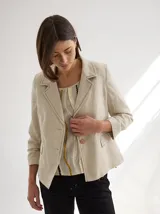 Blazer color mostaza de lino con corte estructurado, solapas con pespuntes y bolsillos con solapa.
