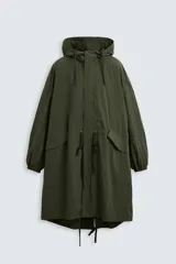 Parka verde militar de tejido técnico ligero, corte oversize, cuello alto con capucha ajustable, manga larga con puños elásticos, cintura ajustable con cordón interno, bolsillos con solapa, bajo asimétrico con abertura trasera ajustable y cierre frontal con cremallera oculta y botones a presión.