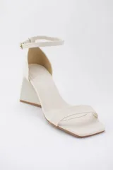 Sandalias negras de cuero sintético con punta cuadrada, tira delgada sobre los dedos y pulsera con hebilla al tobillo. Taco geométrico triangular. Marca Trend.