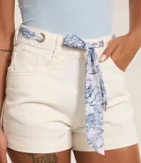 Short de jeans color crudo, de corte slim y cintura alta. Incluye cinturón tipo pañuelo con estampado floral.
