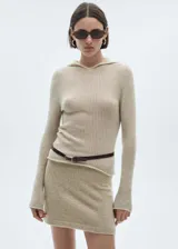 Sweater de punto fino color beige con capucha y mangas largas.