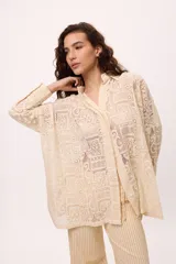 Camisa blanca oversize de algodón con cuello clásico, mangas largas y puños abotonados con detalle de tablas.