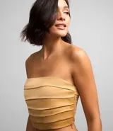 Blusa cropped color beige de satén con escote strapless, diseño con pliegues horizontales y cierre lateral con cremallera invisible.