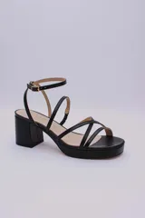 Sandalias negras de cuero con plataforma y taco cuadrado, tiras finas sobre el empeine y pulsera al tobillo con hebilla.