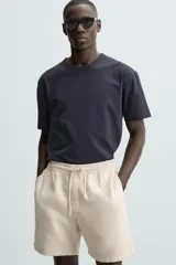 Bermuda de algodón color marrón oscuro, de corte regular fit, con cintura elástica ajustable mediante cordón. Presenta bolsillos laterales y un bolsillo trasero de vivo.