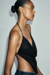 Top negro con escote drapeado y tiras finas ajustables en cuello y espalda. Detalle de aplicación de abalorios.
