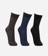 Kit de tres pares de medias de caña larga color negro, confeccionadas en algodón con textura acanalada.