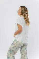 Camisa celeste amplia de manga corta, con cuello clásico y botones al frente.