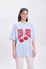 Remera celeste de corte amplio con estampado de cerezas rojas y texto "Red Cherry".