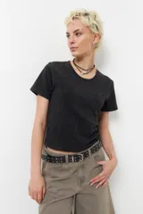 Remera de manga corta de tela desgastada, color negro, con ajuste clásico.
