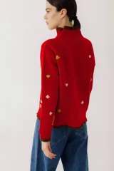 Sweater crudo de tejido de punto con cuello alto con volados y bordados de símbolos de naipes.