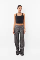 Pantalón de cuerina gris con estampado abstracto, corte recto y tiro medio. Presenta cierre metálico, botón tipo broche y bolsillos laterales.