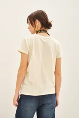 Remera de calce holgado confeccionada en jersey de algodón color crudo, con estampa central de mariposa con detalles bordados y lentejuelas.