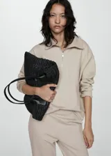 Sweater beige de cuello alto con cierre de cremallera, diseño oversize y mangas largas.