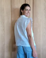 Musculosa celeste de denim con cuello mao con volados y cierre frontal con botones.